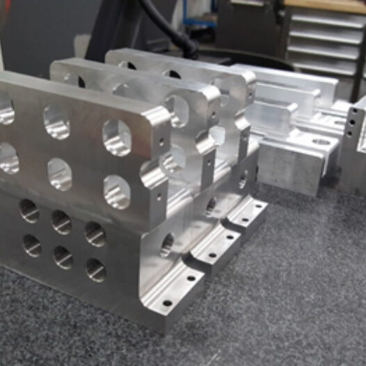 Stacked aluminum fixture components with precise holes and cuts for industrial applications.